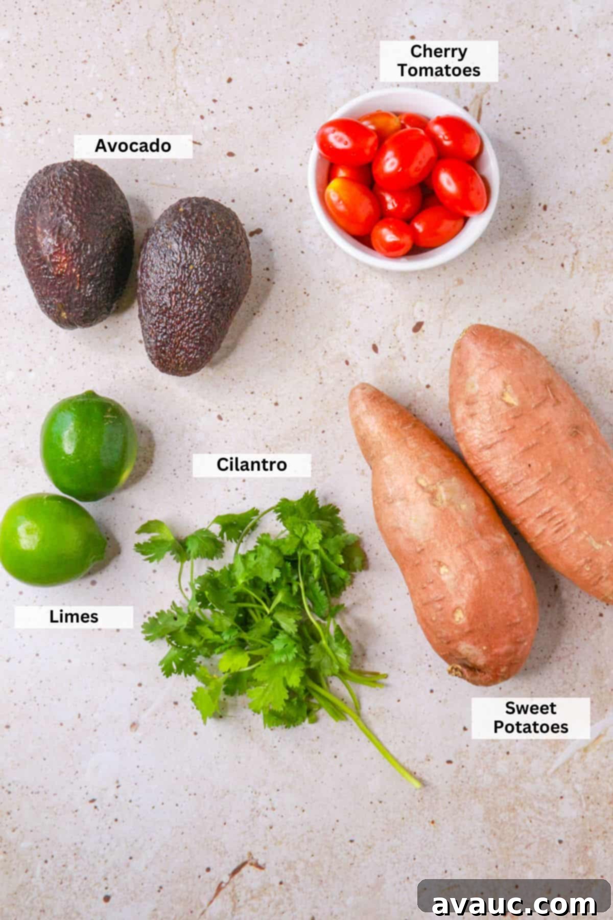 Sweet Potato Avocado Salad 3 Ingredients for ensalada de camote: cherry tomatoes, avocados, sweet potatoes, limes, cilantro arranged on a wooden board