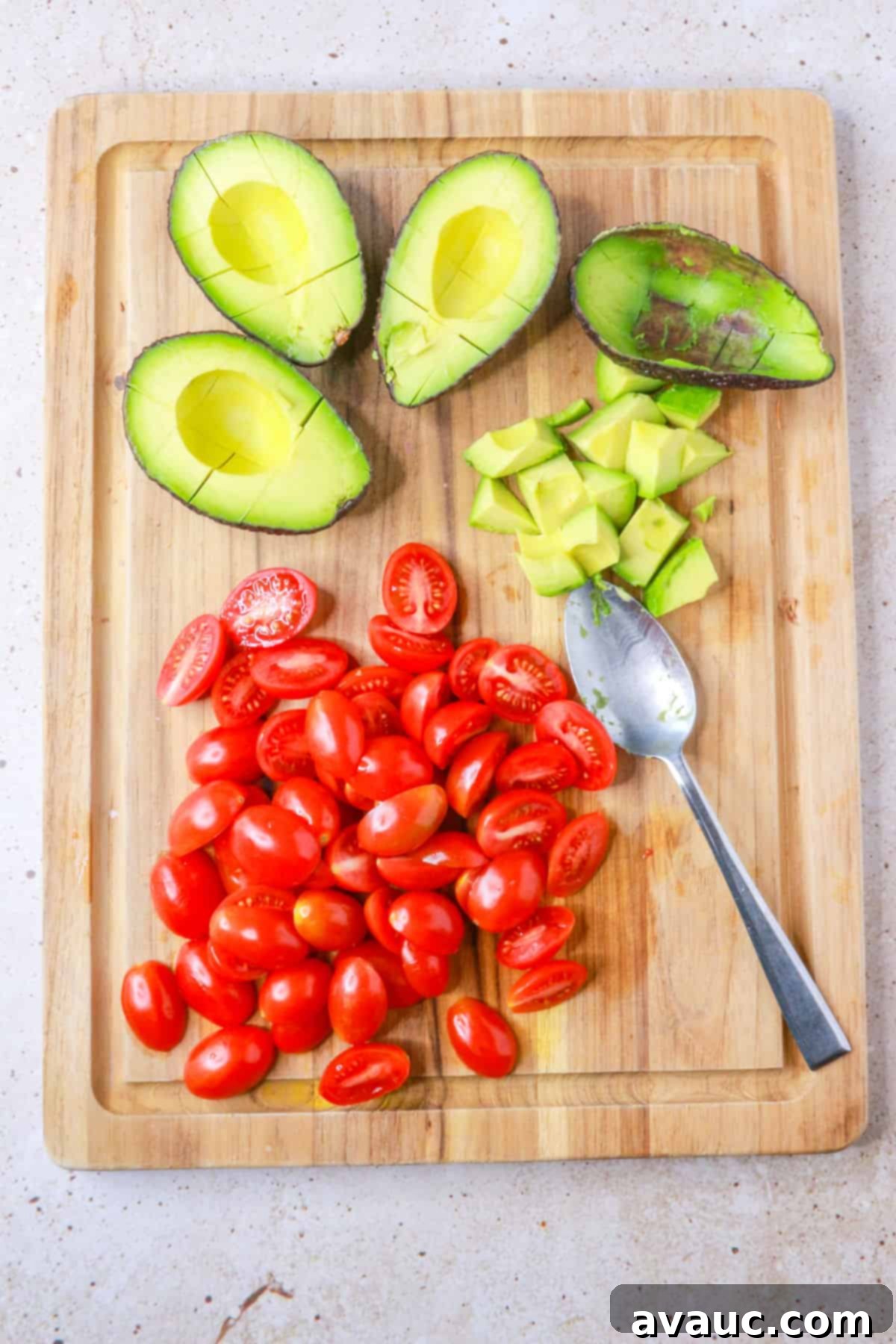 Sweet Potato Avocado Salad 6 diced avocados and halved cherry tomatoes on a cutting board, prepped for salad