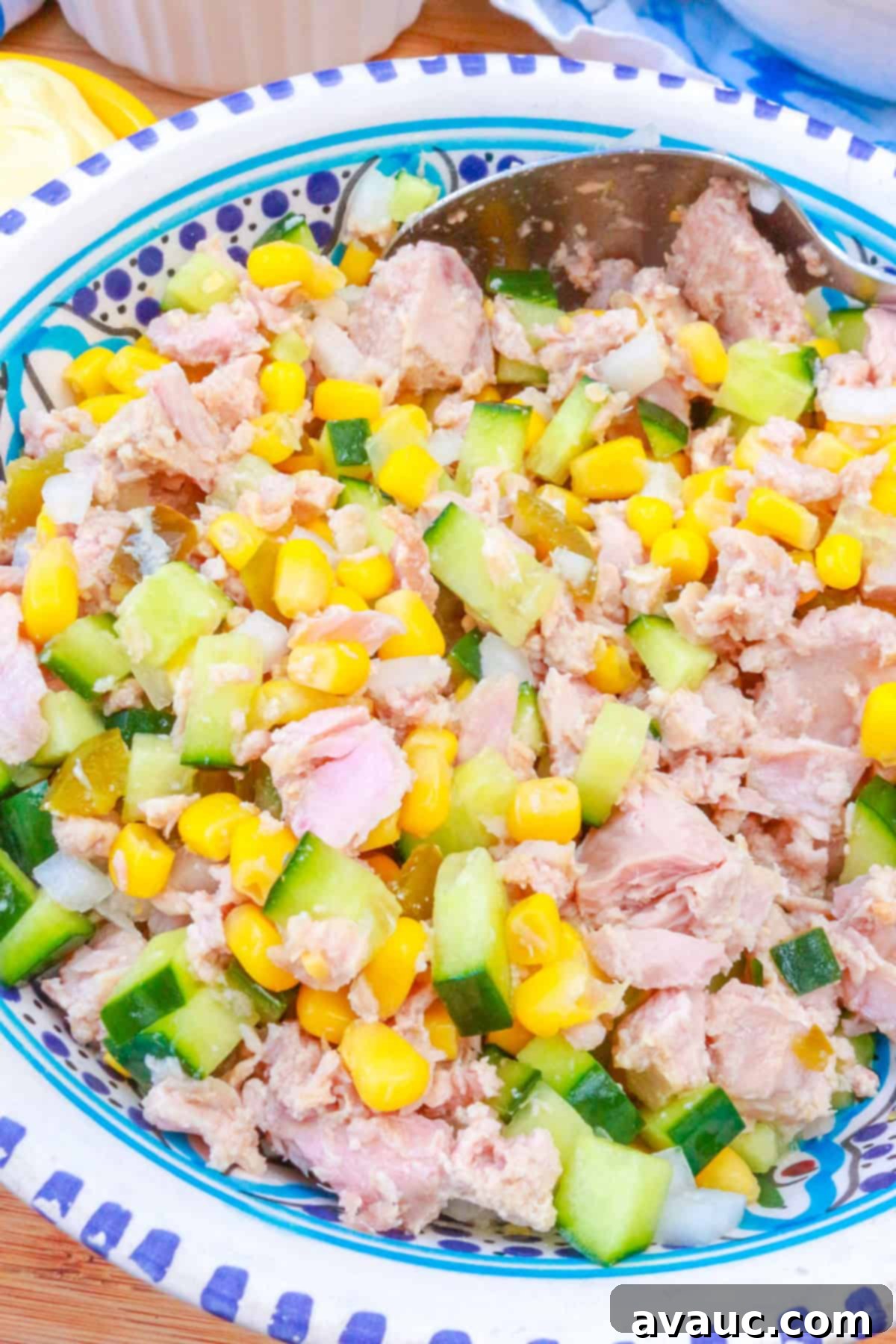A bowl with tuna, canned corn, diced cucumber, diced onion and diced pickled jalapeños.