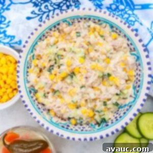 Bowl of Ensalada de Atun (Mexican tuna salad) with a bowl of corn and another with pickled jalapeños beside it.