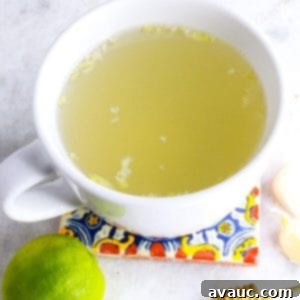 Homemade Garlic Tea Elixir 10 A perfectly brewed mug of garlic tea, garnished with a lime slice, on a rustic coaster, ready to be enjoyed for its health benefits.