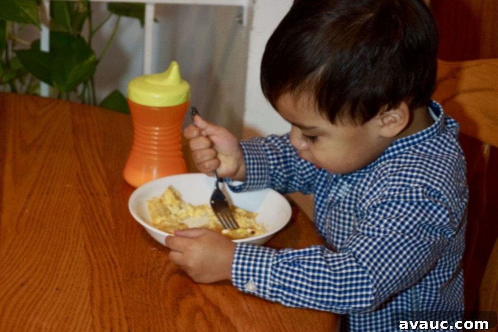 My son enjoying a plate of homemade huevos con tortilla, a perfect easy breakfast for kids. #breakfastforkids #easybreakfast