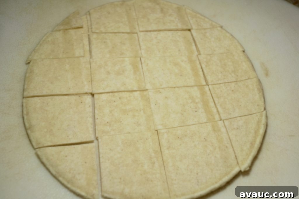Cutting corn tortillas into squares for huevos con tortilla preparation.