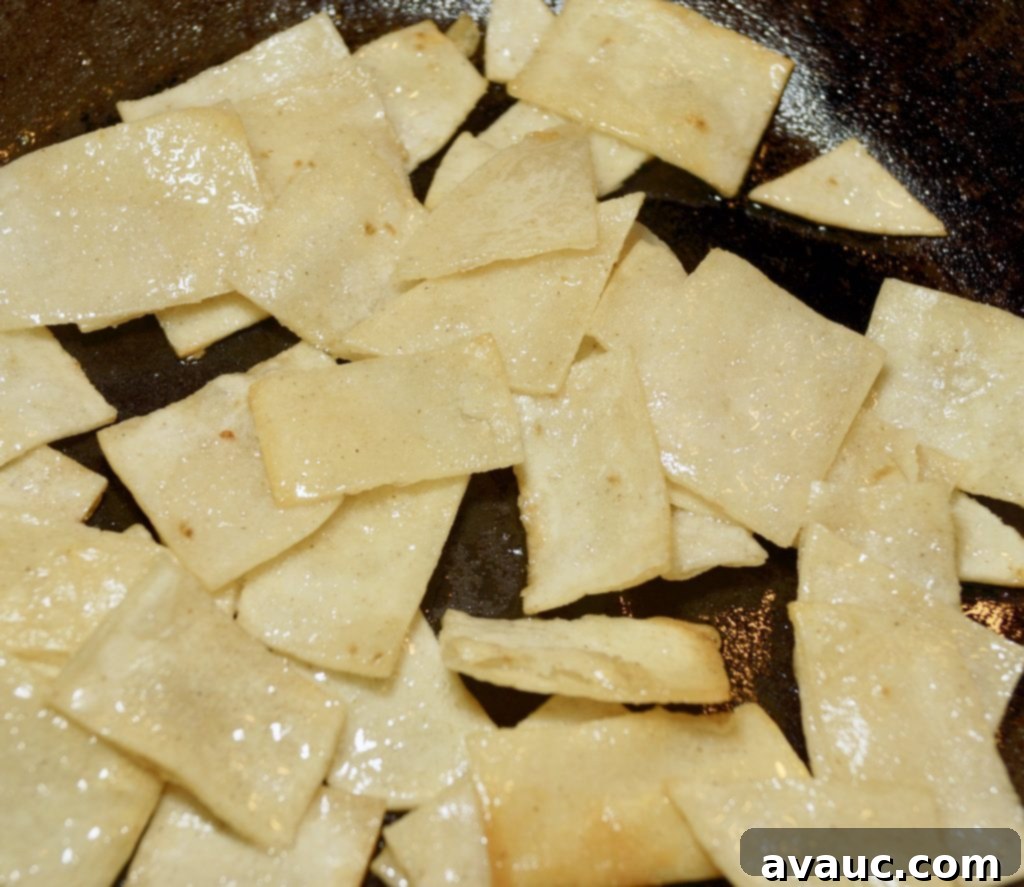 Frying corn tortillas until crispy and golden for huevos con tortilla. #huevocontortillas #easybreakfast