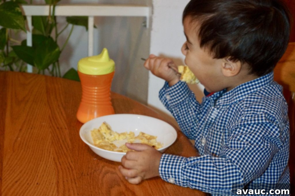 My son happily eating huevos con tortilla, a nutritious and easy breakfast option for children. #breakfastforkids #easybreakfast