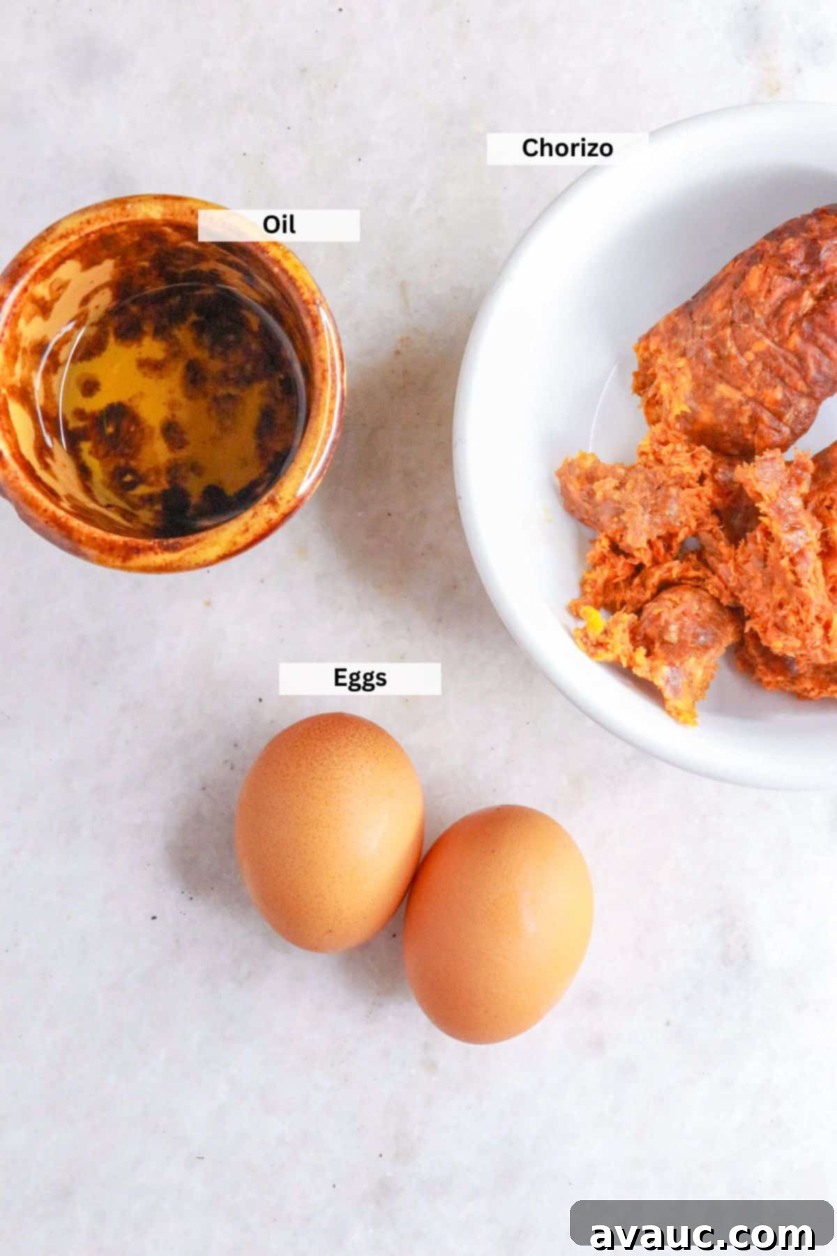 Ingredients for huevos con chorizo: Small bowl with oil, bowl with raw chorizo, 2 eggs