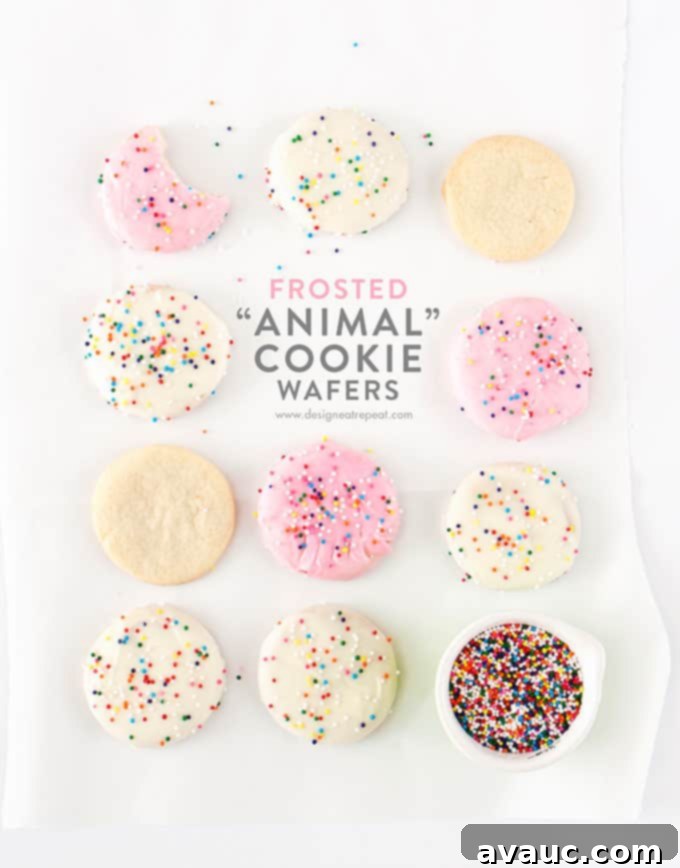 Crispy Frosted Animal Cookie Wafers 2 Homemade Frosted Animal Cookie Wafers with pink and white frosting and sprinkles on a wire rack.