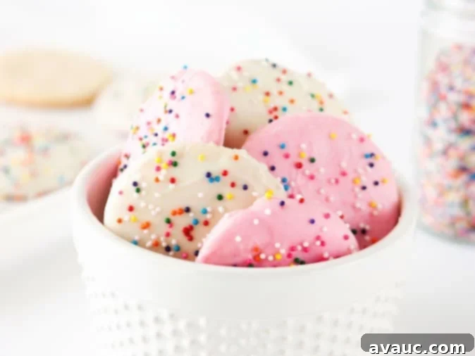 Crispy Frosted Animal Cookie Wafers 11 A collection of finished Homemade Frosted Animal Cookie Wafers with pink and white frosting and colorful sprinkles.