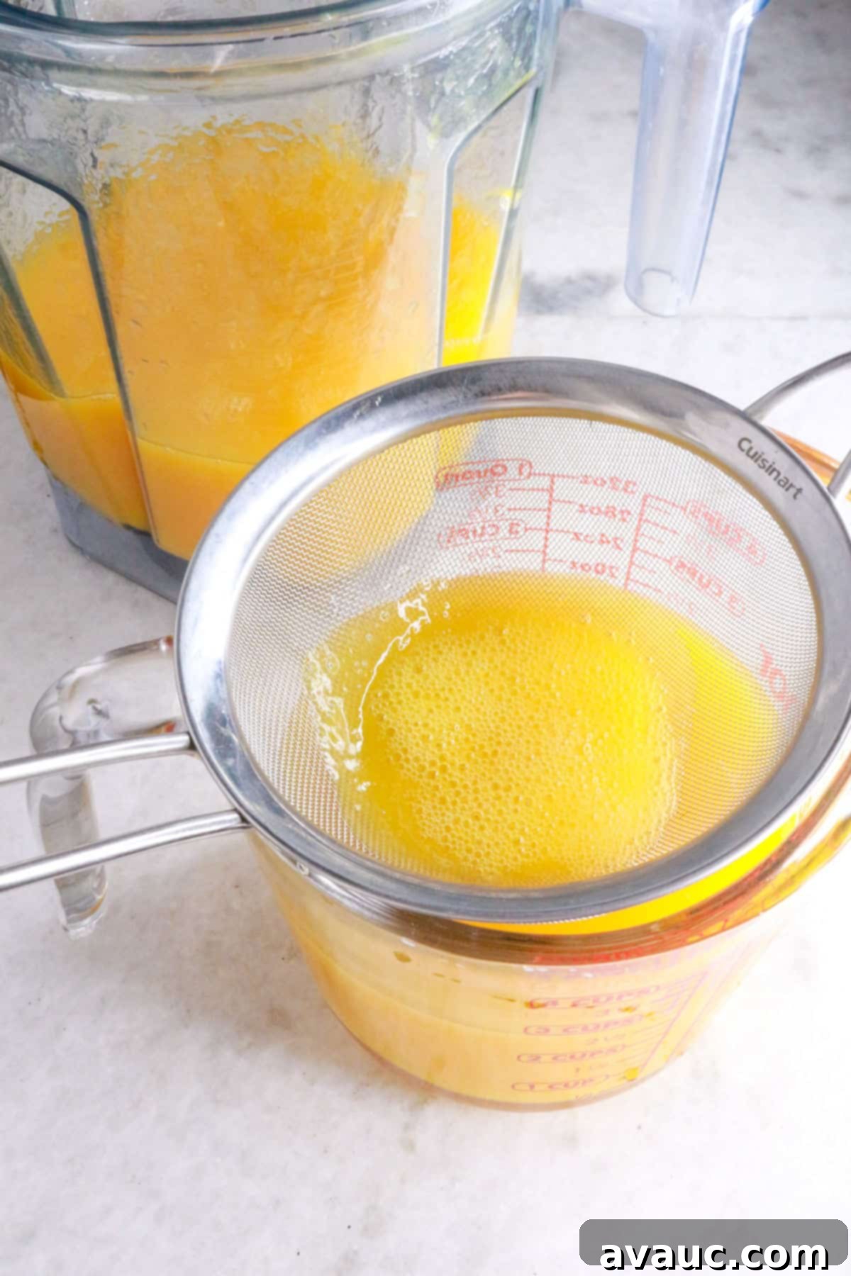 Simple Refreshing Mango Agua Fresca 7 Straining mango agua fresca into a glass container