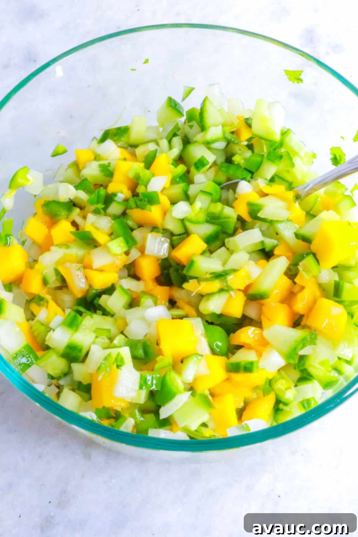 Mixing diced ingredients for mango pico de gallo