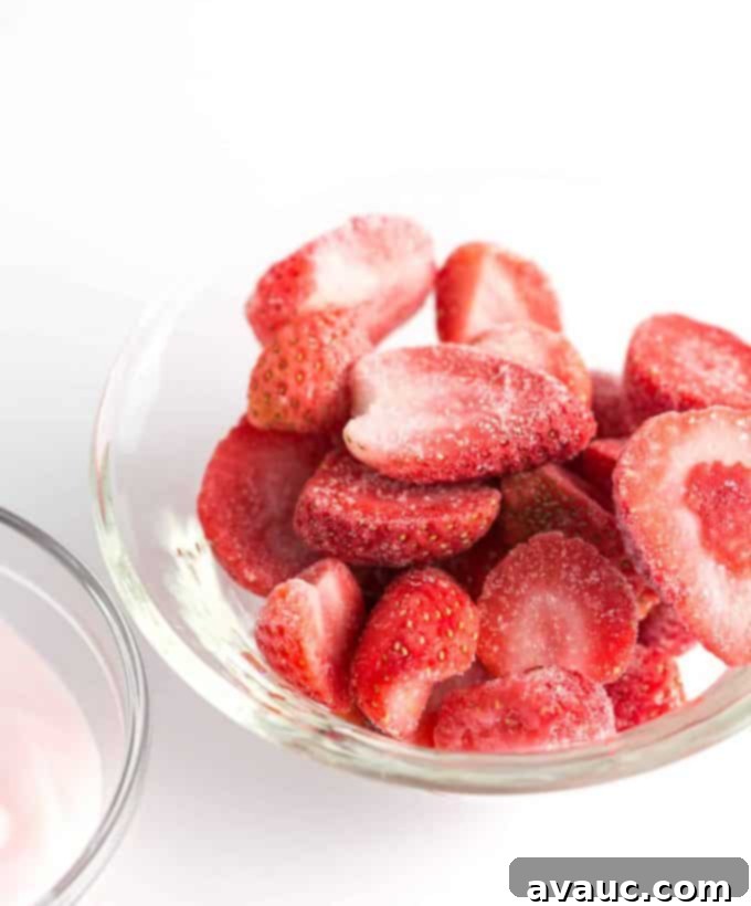 Close-up of a glass of Strawberry Cream Vanilla Bean Frappuccino with luscious whipped cream topping