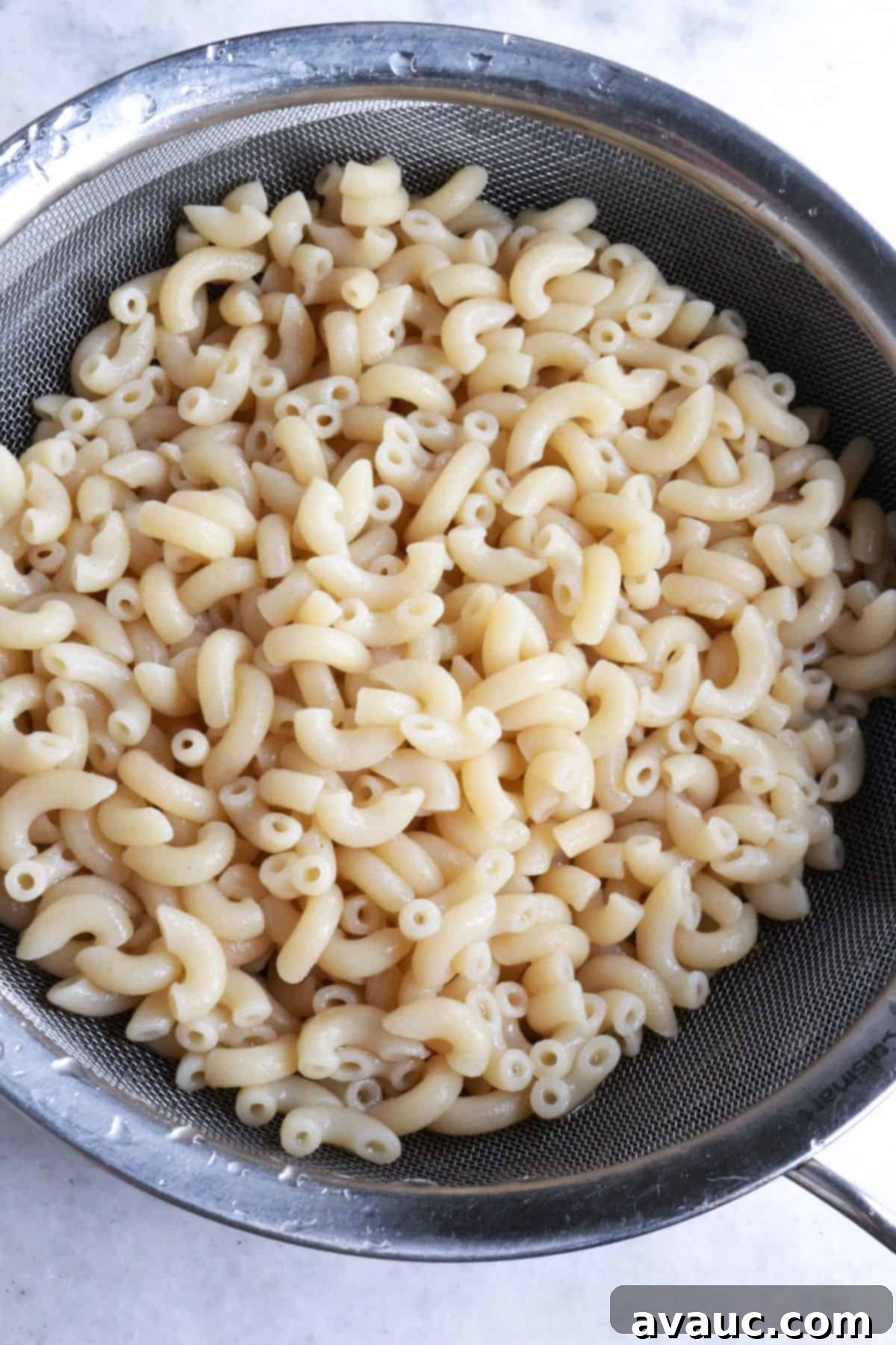 Draining macaroni noodles in a sieve
