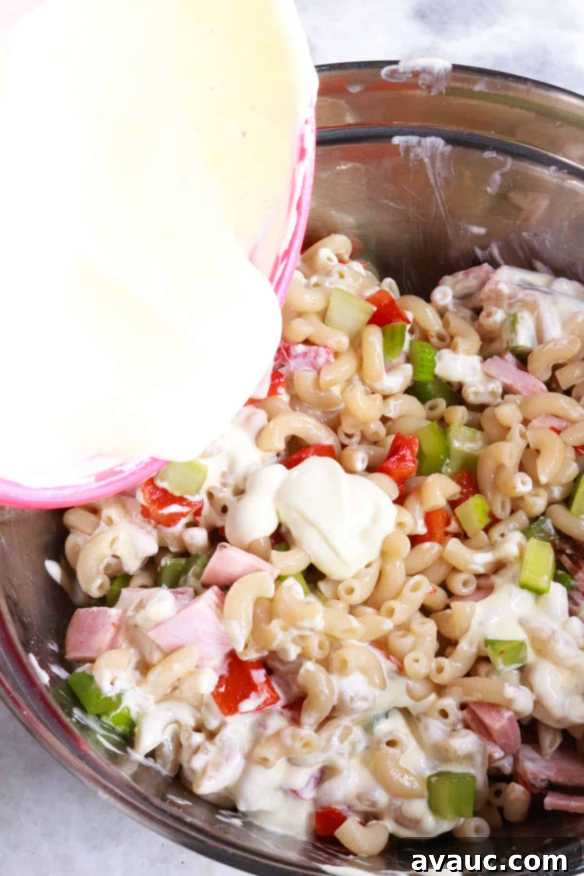 Adding dressing to Mexican pasta salad