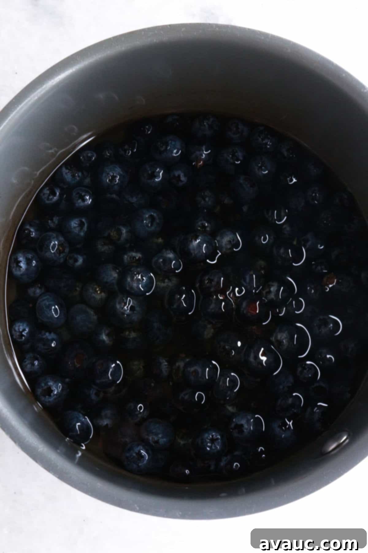 Vibrant Berry Refresher 4 Small pot with fresh blueberries, honey, water, and a pinch of salt, simmering on a stovetop.