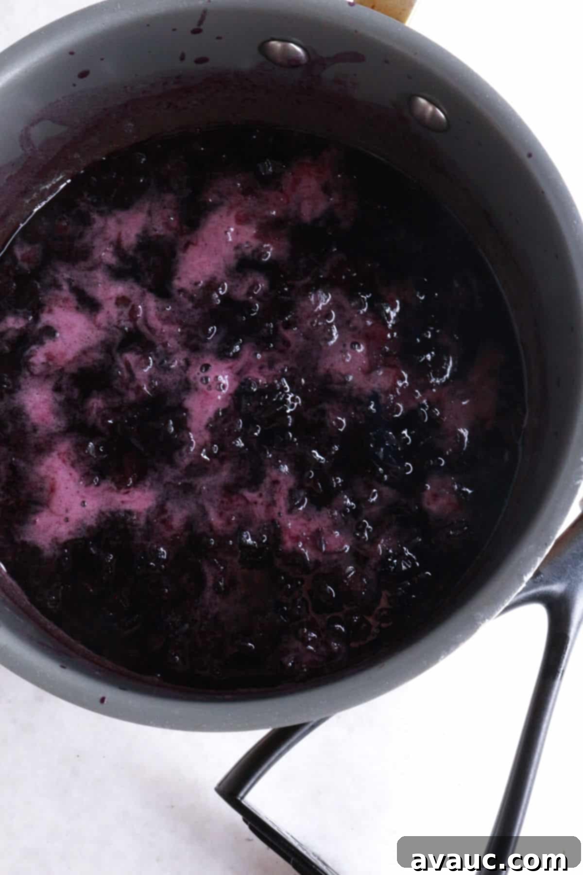 Vibrant Berry Refresher 5 Mashed blueberries in a pot, creating a vibrant simple syrup as they simmer.