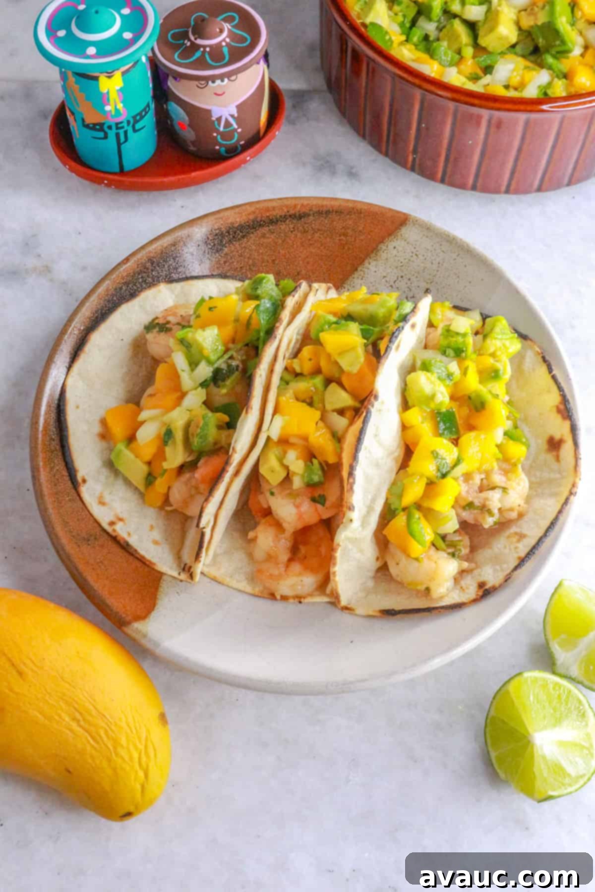 Zesty Shrimp Tacos with Tropical Mango Salsa 11 A plate with three shrimp tacos with mango salsa