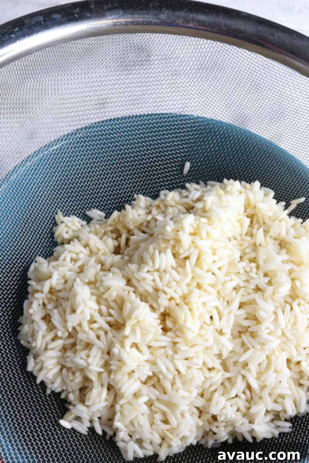 Zesty Mexican White Rice with Sweet Corn 5 Fried white rice being drained of excess oil in a fine mesh sieve