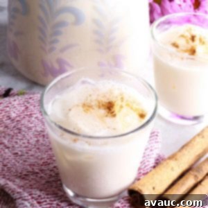 Cooling Horchata Delight 10 Two glasses of horchata agua fresca with a pitcher behind it, ready to serve.