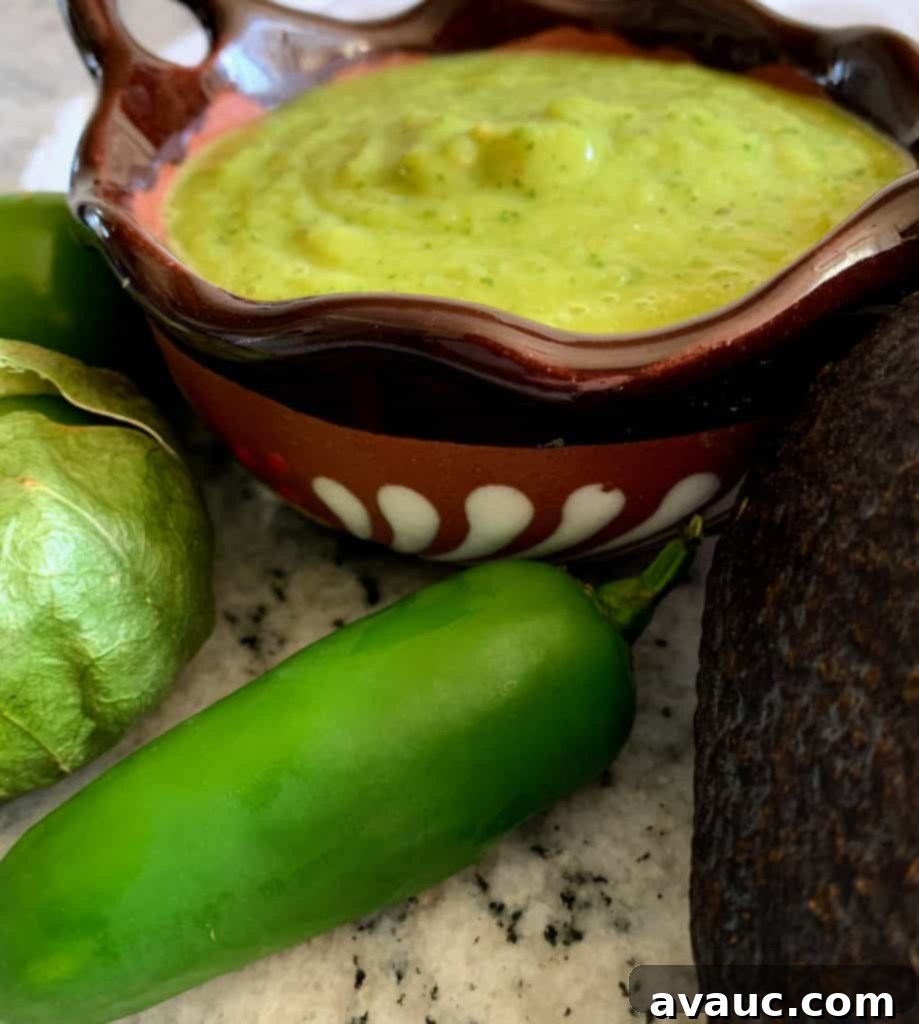 Close-up of creamy tomatillo avocado salsa in a white bowl with fresh ingredients