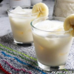 Fresh Banana Drink 8 Two glasses with ice and creamy banana agua fresca garnished with a slice of fresh banana