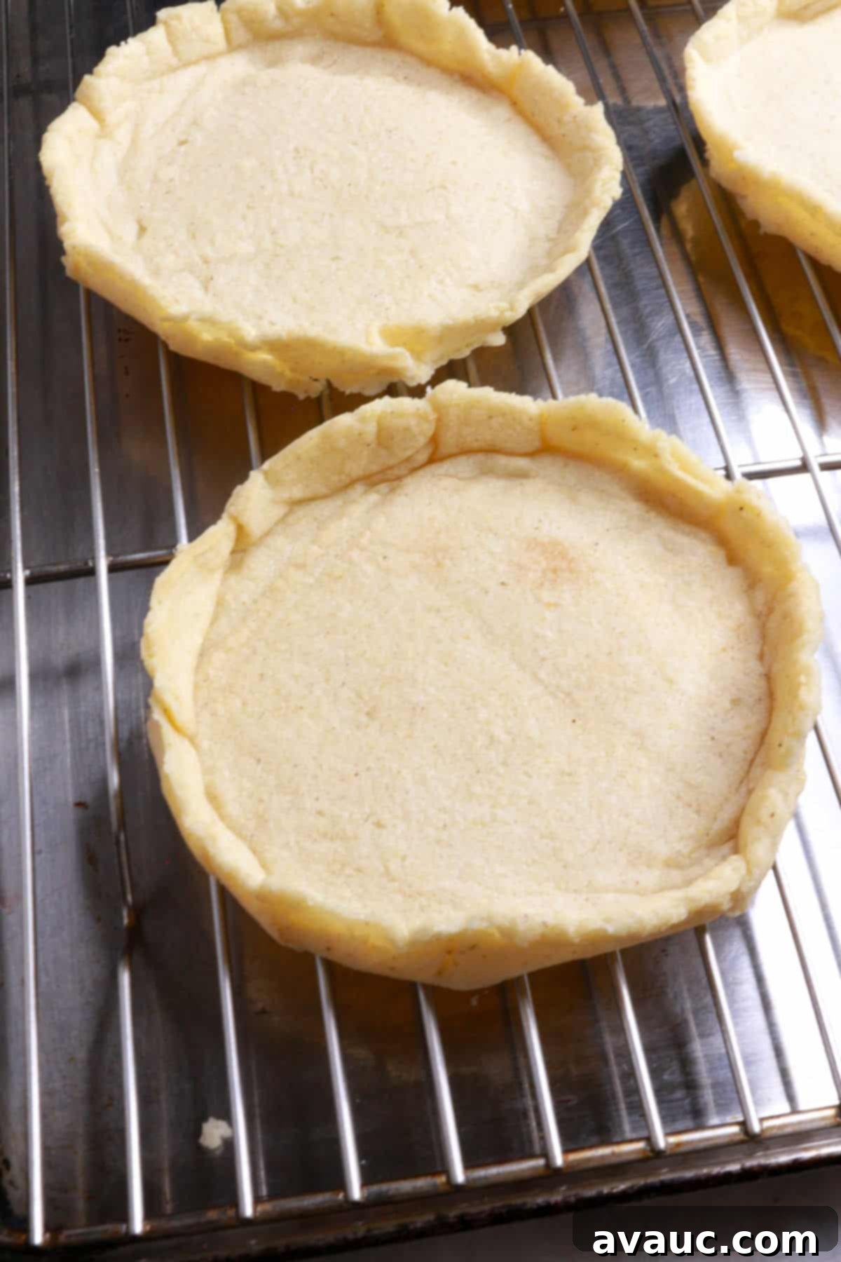 Several par-cooked sopes with freshly pinched ridges cooling on a wire rack