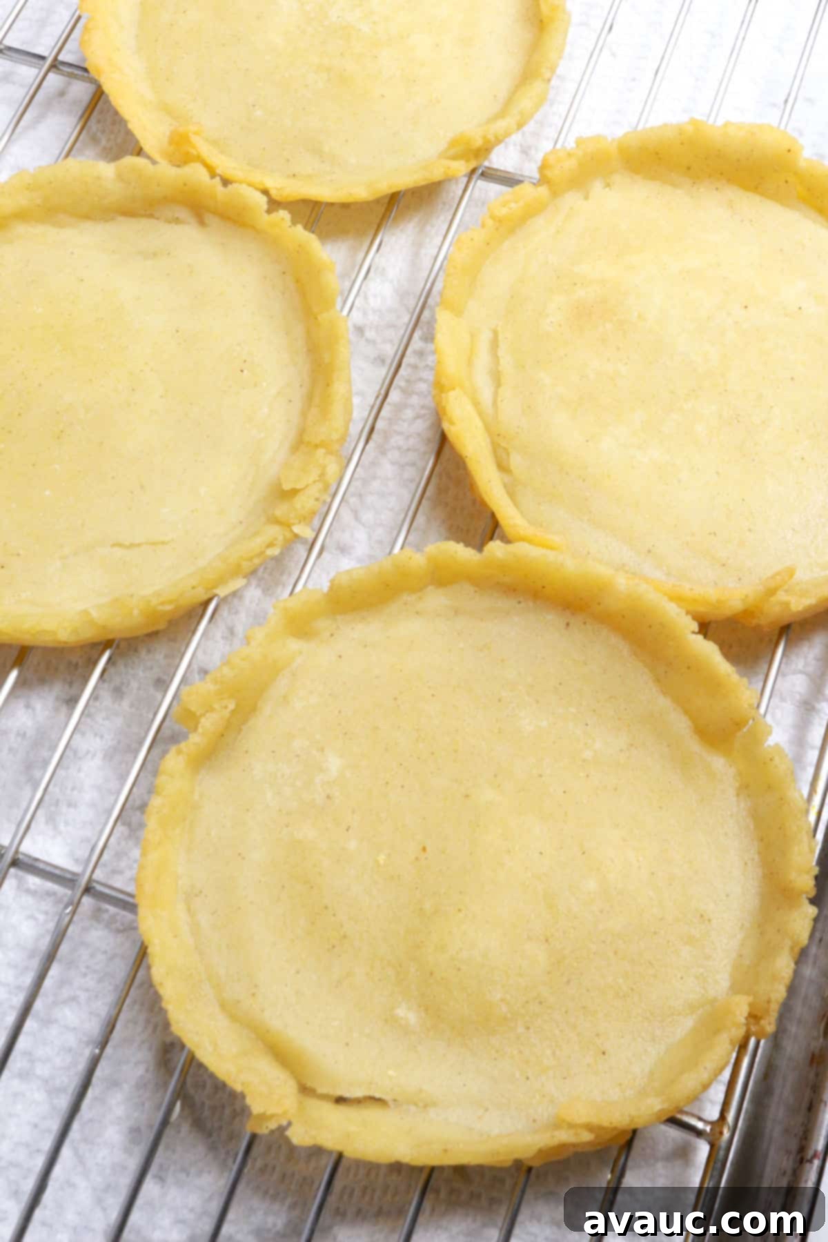 Freshly fried sopes draining excess oil on a wire rack with paper towels underneath