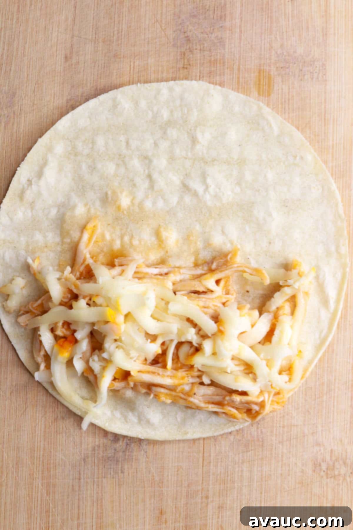 Crunchy Golden Chicken Tacos 9 A warm corn tortilla filled with a generous spoonful of seasoned shredded chicken and a sprinkle of shredded cheese, ready to be folded