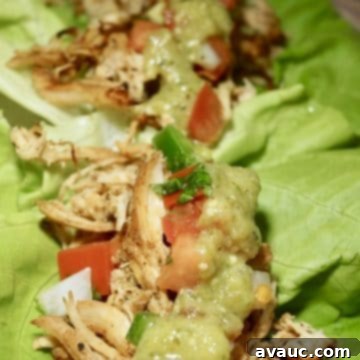 Whole30 slow cooker crispy chicken tacos in lettuce leaves garnished with cilantro and salsa.