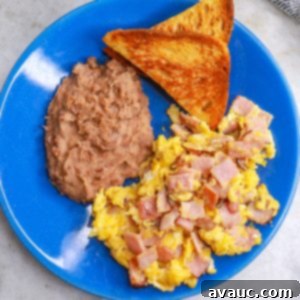 Classic Ham and Egg Scramble 10 a plate with huevos con jamon, refried beans and toast