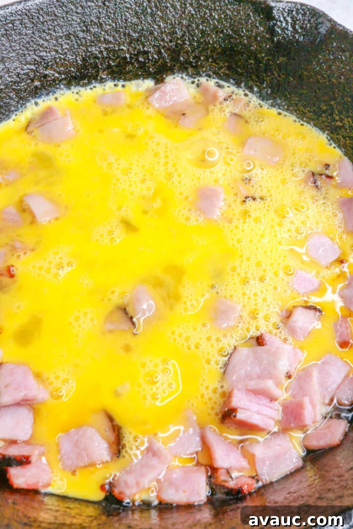 Classic Ham and Egg Scramble 7 cooking eggs and ham in a cast-iron skillet