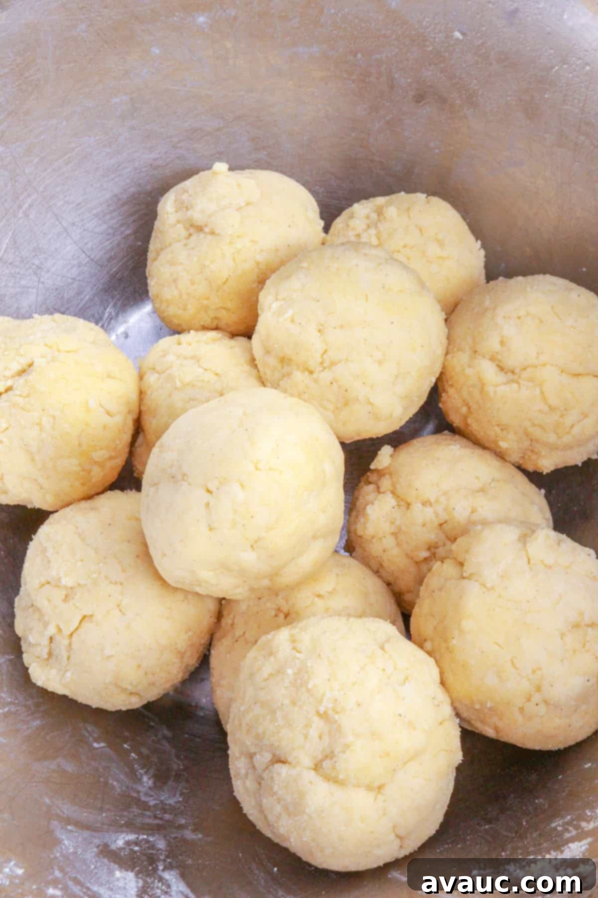 12 balls of dough in a metal bowl