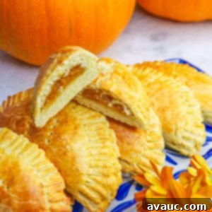 Cut empanada de calabaza on top of other pumpkin empanadas on a platter
