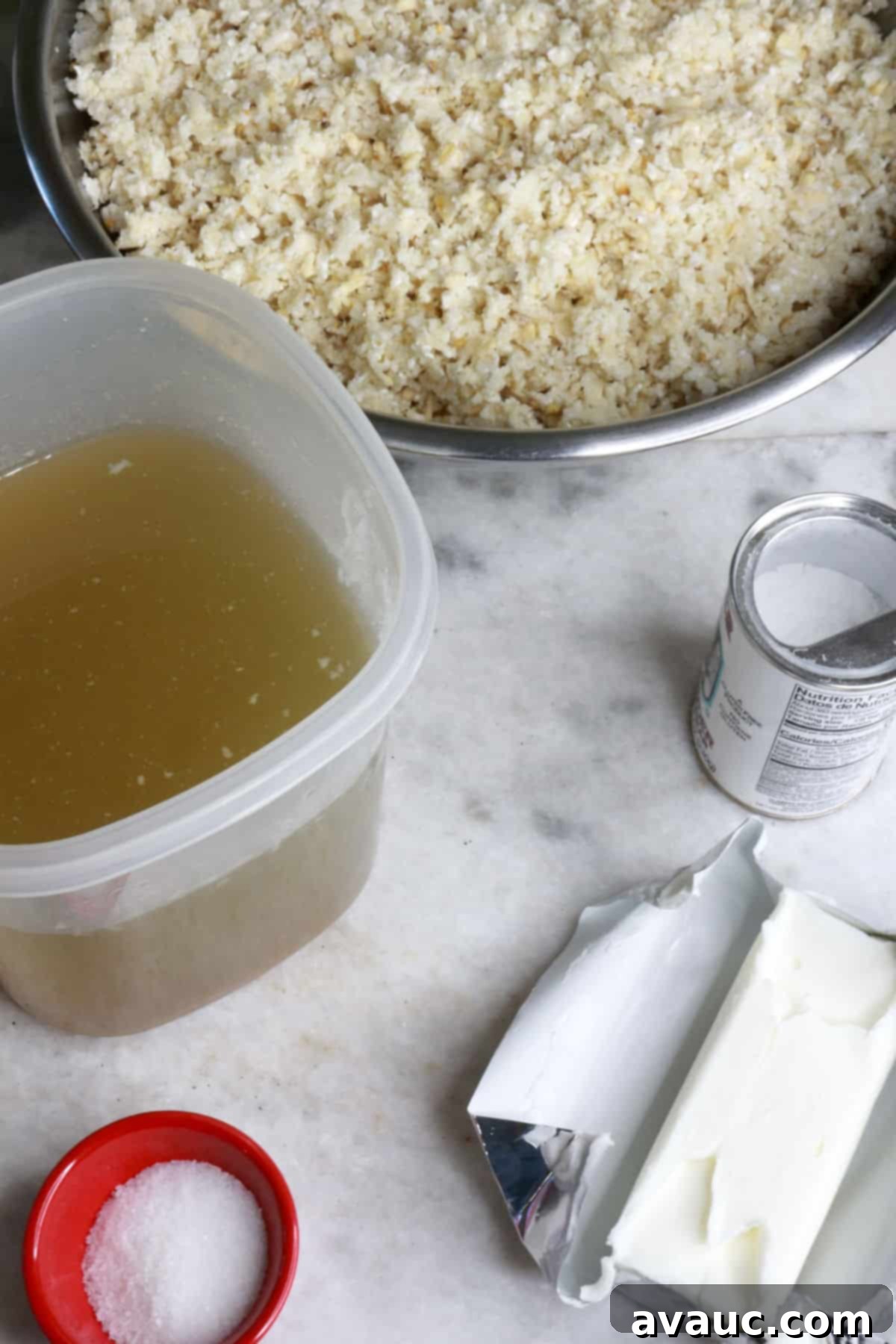 Mastering Nixtamalization for Authentic Tamales 4 A bowl of freshly ground masa, with containers of pork broth, baking powder, shortening, and a pinch bowl of salt, ready for mixing to create tamale dough.