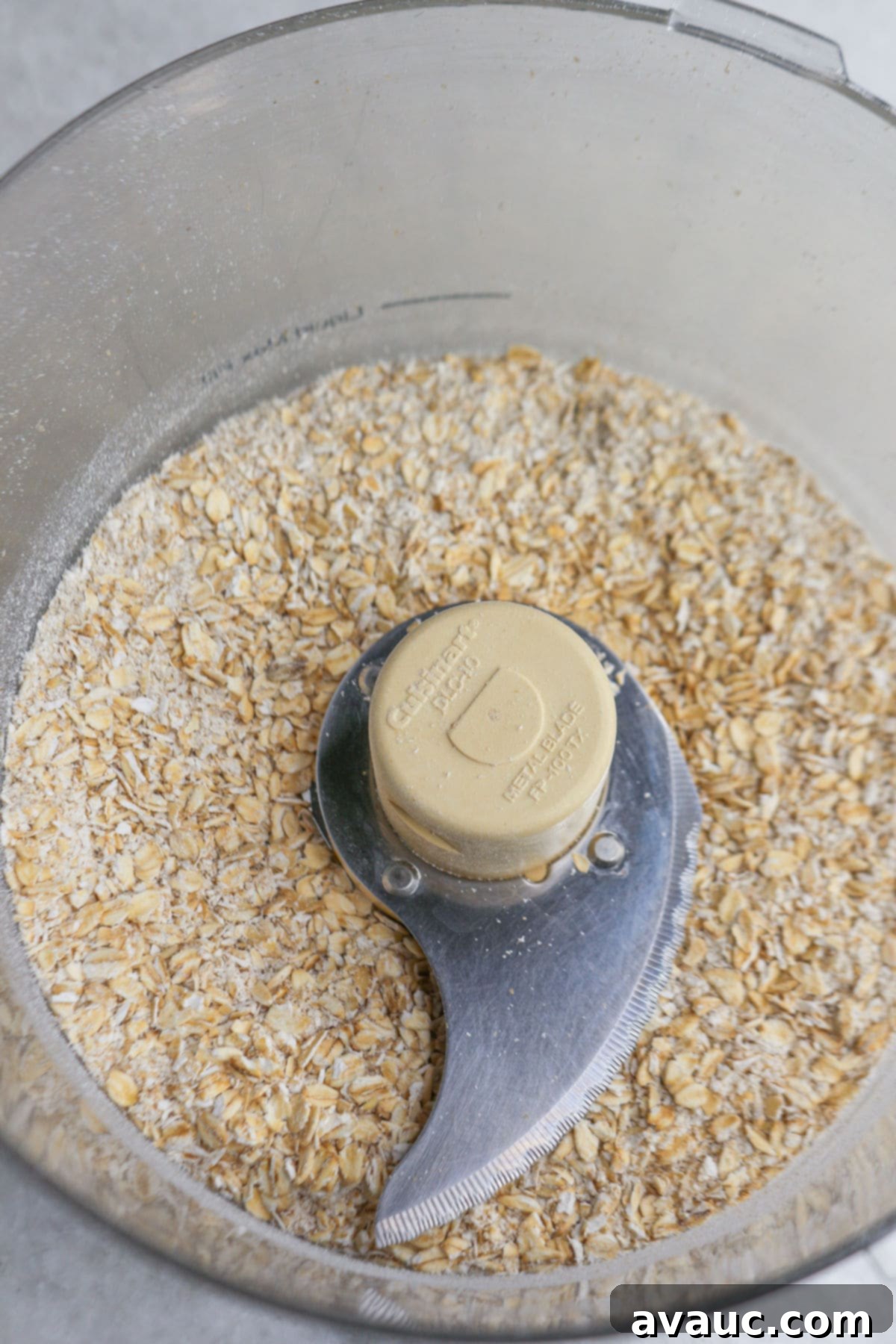 Old-fashioned oats partially blended in a food processor, showing a slightly broken-down texture.