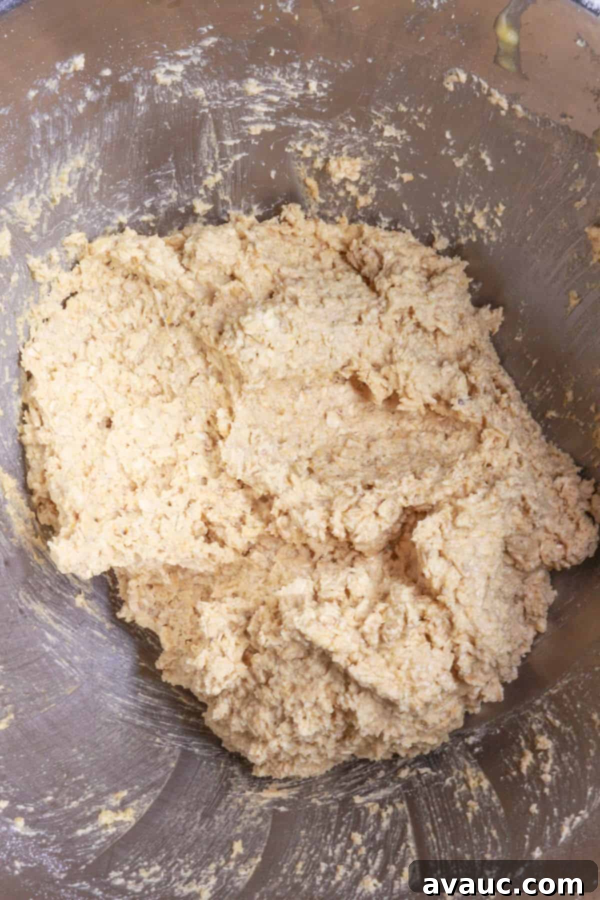 Finished coconut oatmeal cookie dough in a large mixing bowl, ready for scooping.