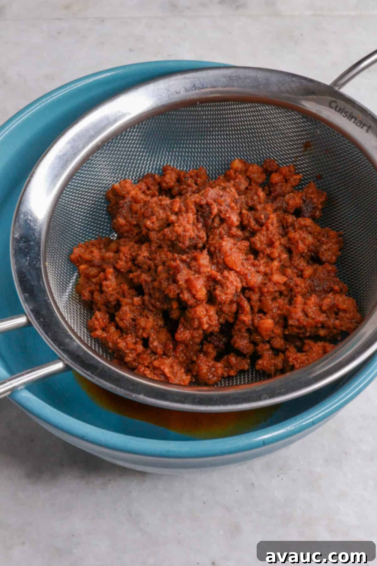 Spicy Chorizo Queso Dip 5 Cooked chorizo being drained in a mesh strainer to remove excess fat, a crucial step for a balanced choriqueso.