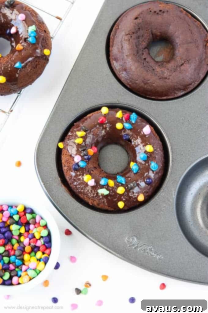Cosmic Triple Chocolate Cake Donuts on in donut pan with rainbow sprinkles