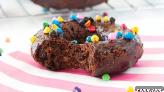 Cosmic Triple Chocolate Cake Donuts on wire rack with rainbow sprinkles