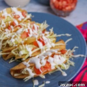 Golden Crispy Potato Tacos 11 Plate of crispy tacos de papa topped with cabbage, tomatoes and sour cream