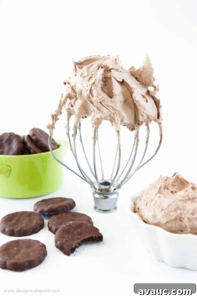 Rich and creamy homemade Thin Mint Buttercream piped on a chocolate cupcake, topped with crushed cookies.