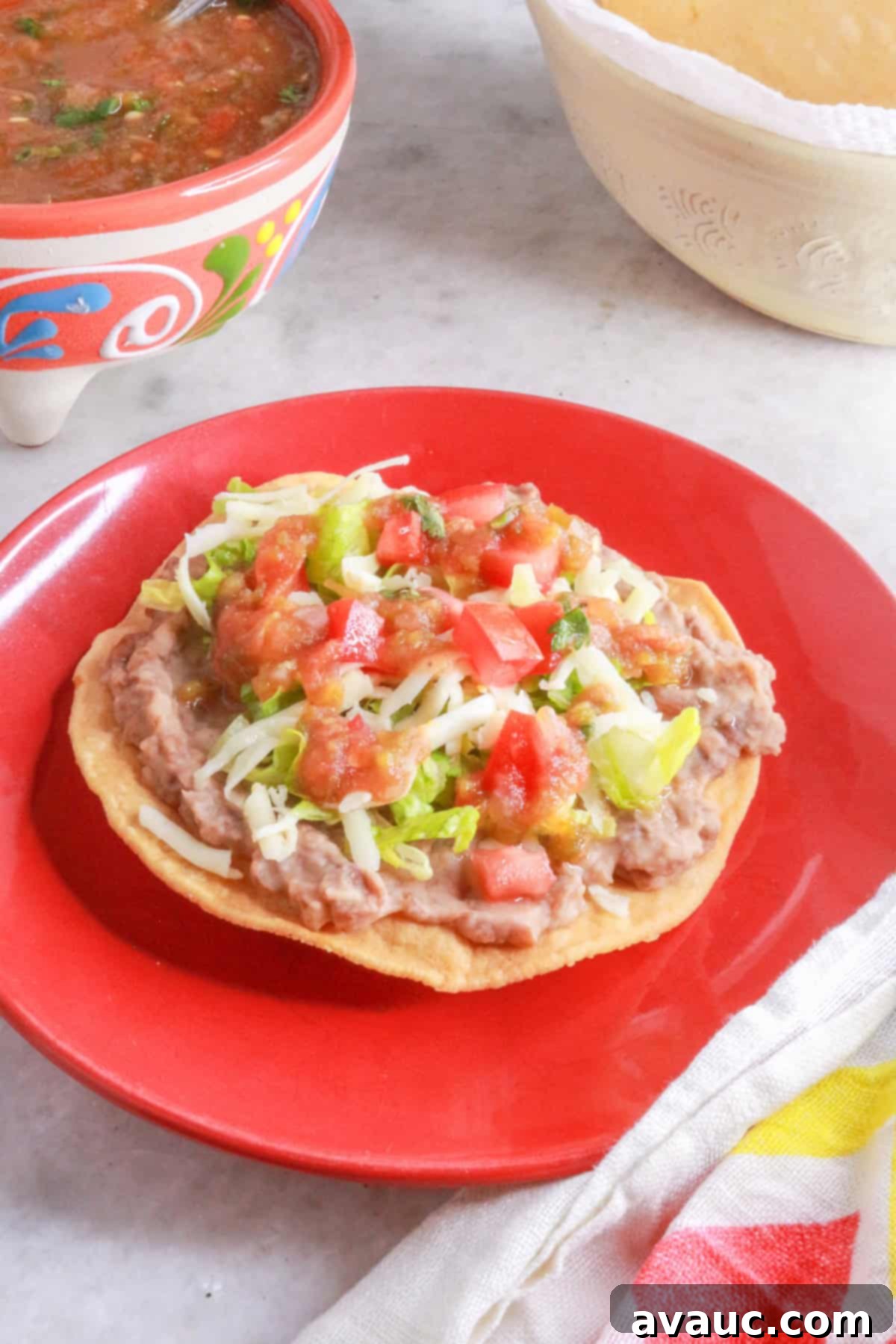 Crispy Bean Tostadas 2 A red plate with a tostada de frijoles