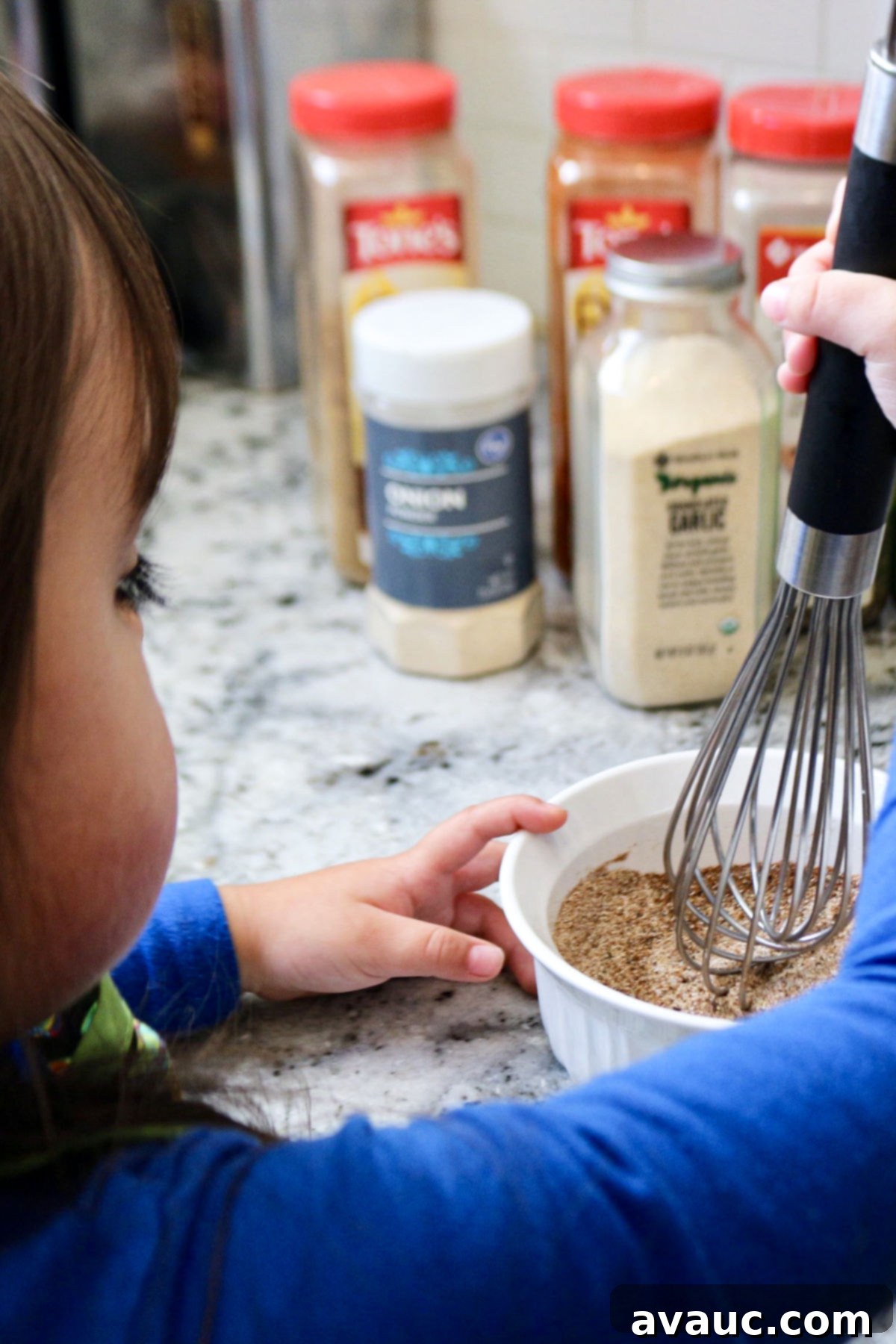Vibrant Sweet Potato Taco Bowl 6 A child helping mix homemade taco seasoning for taco bowl.