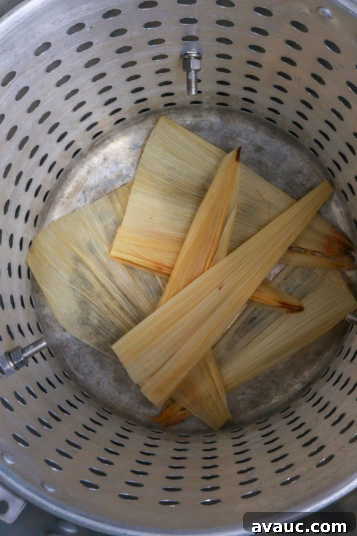 Tamal steamer pot with corn husks at the bottom