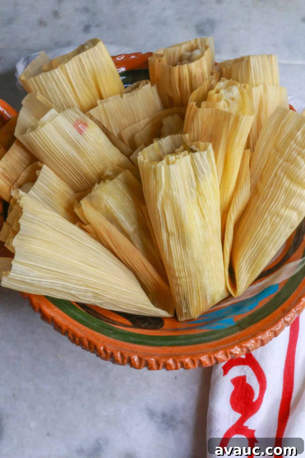 A Mexican clay bowl full of cooked tamales