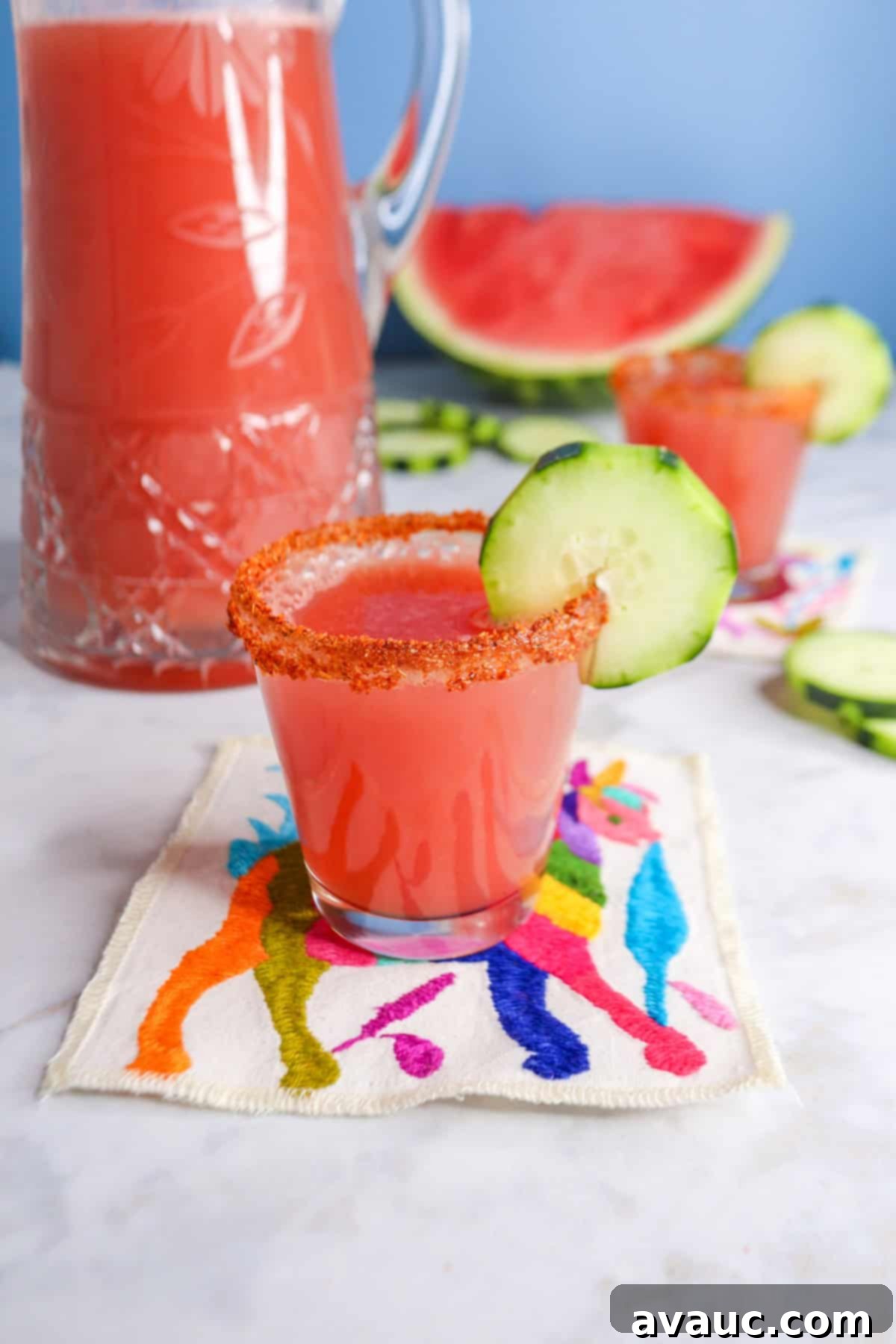 Vibrant Cucumber Watermelon Cooler 11 A refreshing glass of cucumber watermelon agua fresca, beautifully garnished with a cucumber ribbon and a fresh lime wedge, resting on a wooden surface.