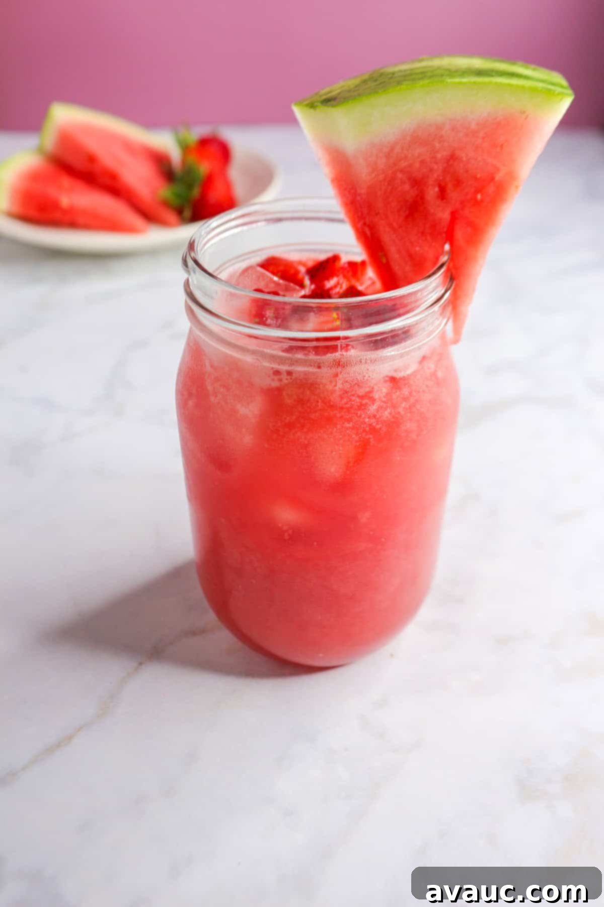 Watermelon Strawberry Agua Fresca 2 A refreshing glass of Watermelon Strawberry Agua Fresca, garnished with a fresh watermelon slice, ready to be enjoyed.