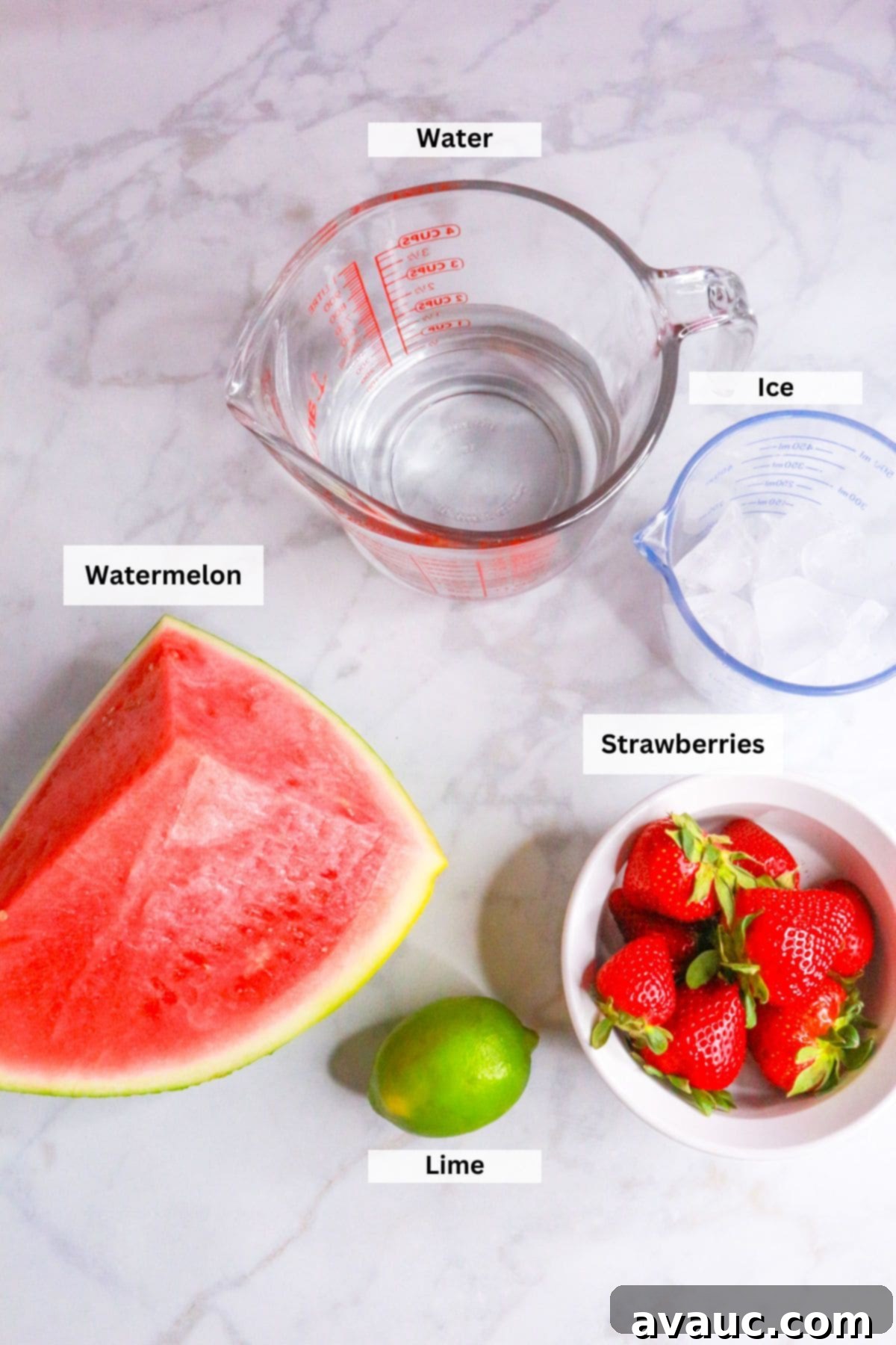 Watermelon Strawberry Agua Fresca 3 Ingredients for Watermelon Strawberry Agua Fresca: Water, ice, cubed watermelon, sliced strawberries, and a fresh lime, arranged on a rustic wooden surface.