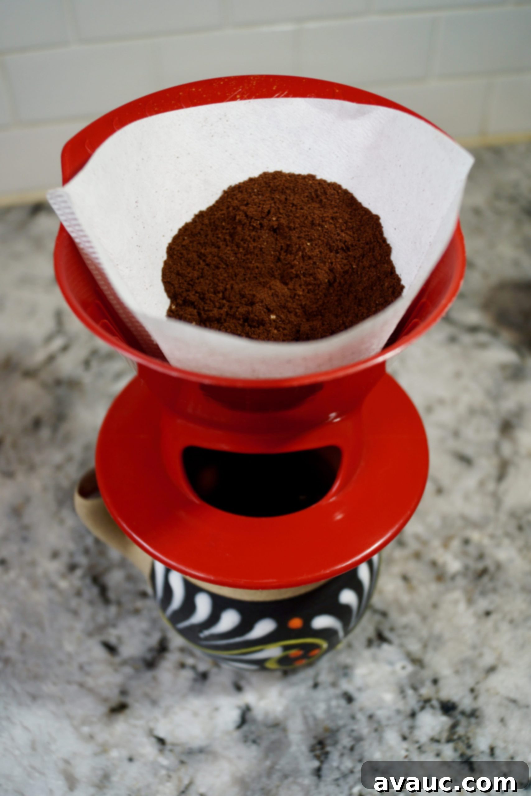 Adding coffee grounds to a cone filter in a pour-over dripper.