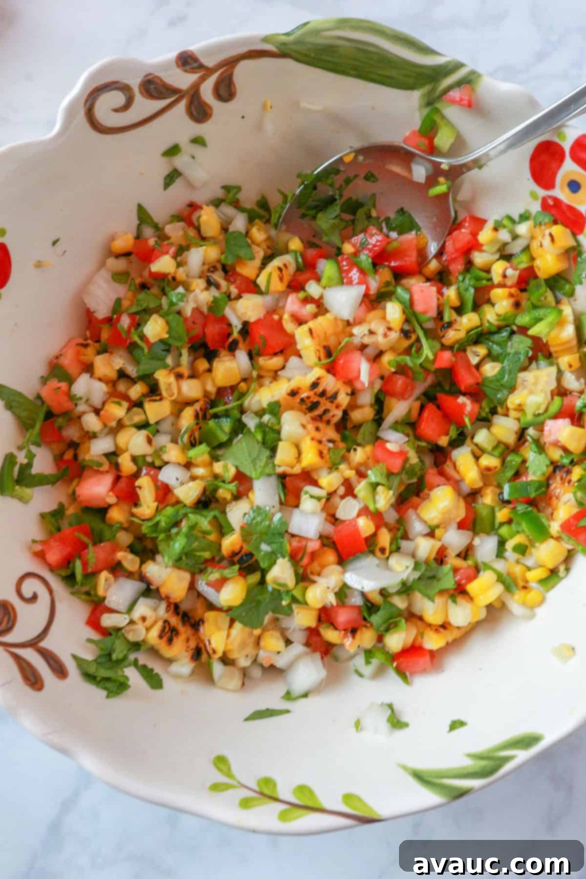 A large, colorful bowl of roasted corn pico de gallo, showcasing the vibrant fresh ingredients.