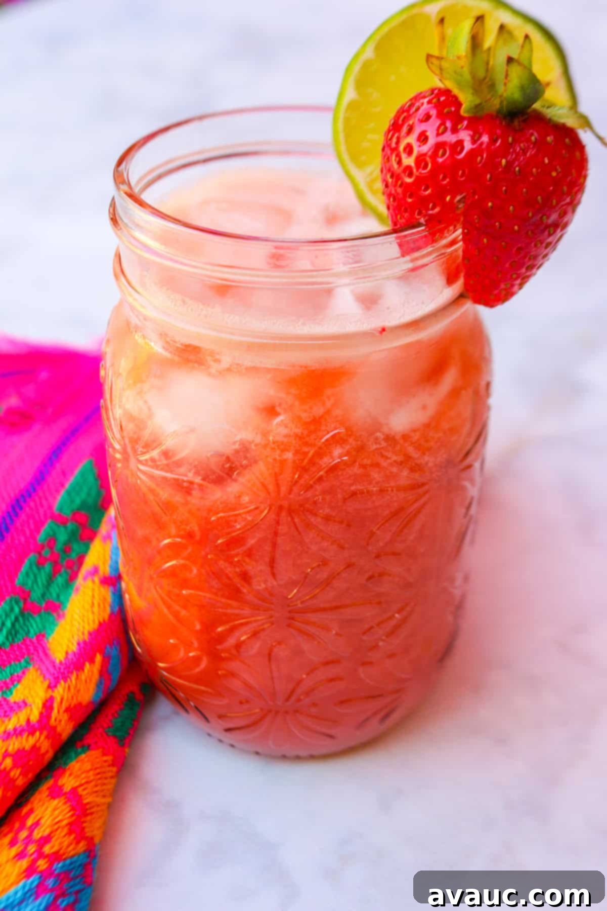 Strawberry Limeade 10 Close up of Limonada de fresa in a glass, with ice and a strawberry garnish
